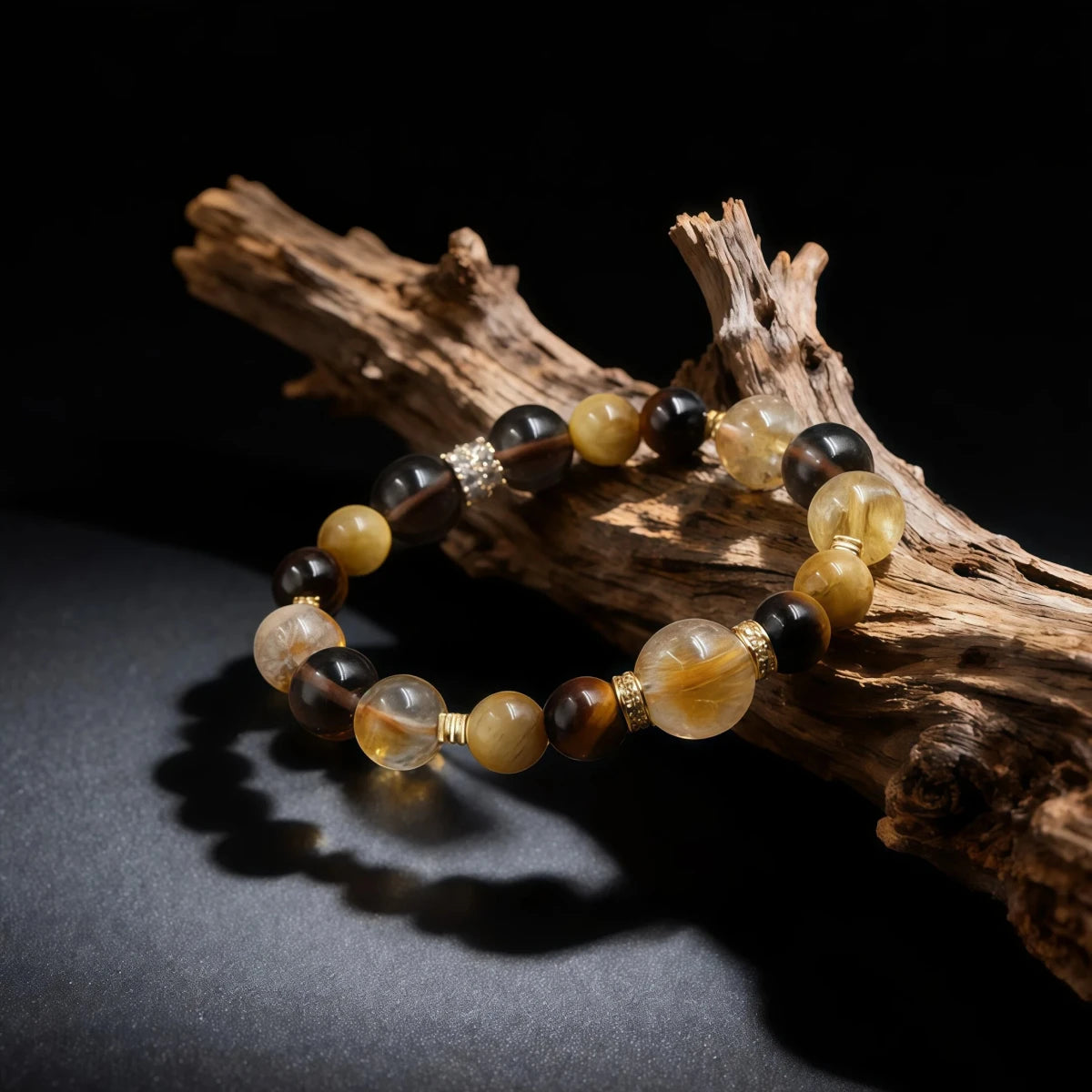 Beaded bracelet with gold accents on a piece of driftwood against a dark background