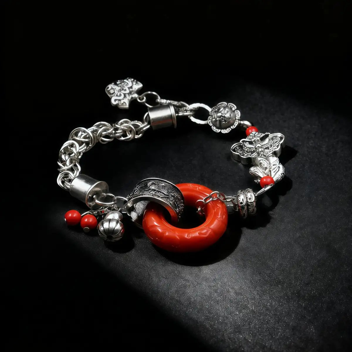 Tibetan Silver bracelet with red charm on a black background