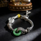 Tibetan Silver bracelet with green and yellow beads on a dark surface