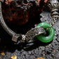 Tibetan Silver bracelet with a green stone on a dark textured surface