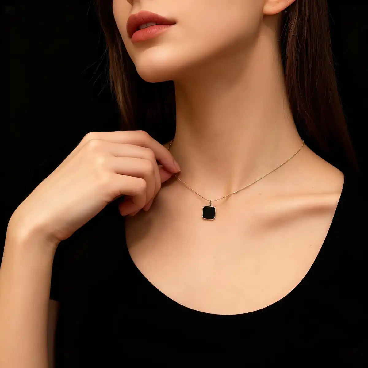 Woman wearing the Black CZ cube necklace, highlighting its elegant fit and modern minimalist style at the neckline.