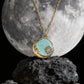 Necklace with a pendant in front of a moonlit rock