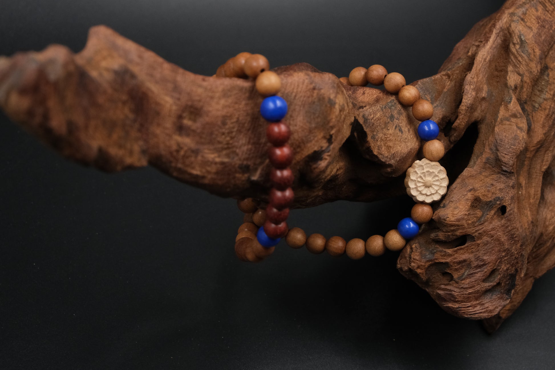 Buddhist Prayer Beaded bracelet with blue and red beads on a dark background