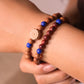 Close-up of a wrist wearing multi-cycle Buddhist Prayer beaded bracelets with blue and brown beads.