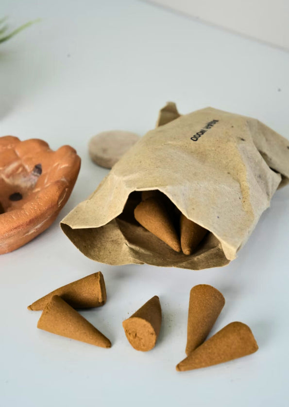 Incense cones spilling out of a brown paper bag on a white surface