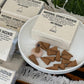 Sandalwood natural cone incense on a white plate with packaging in the background.