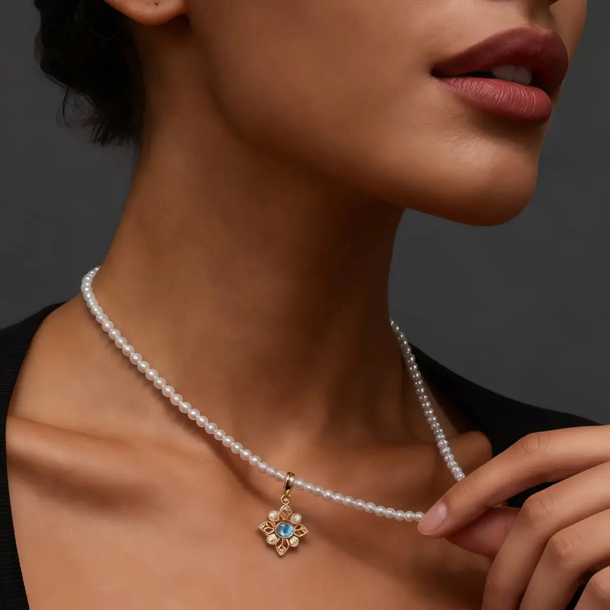 Pearl necklace with a gold pendant featuring a moonstone worn by a model.