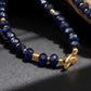 Beaded bracelet with blue beads and gold accents on a dark surface