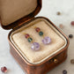 Colorful beaded earrings in a brown jewelry box on a light background