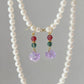 Pearl necklace with matching earrings on a gray background