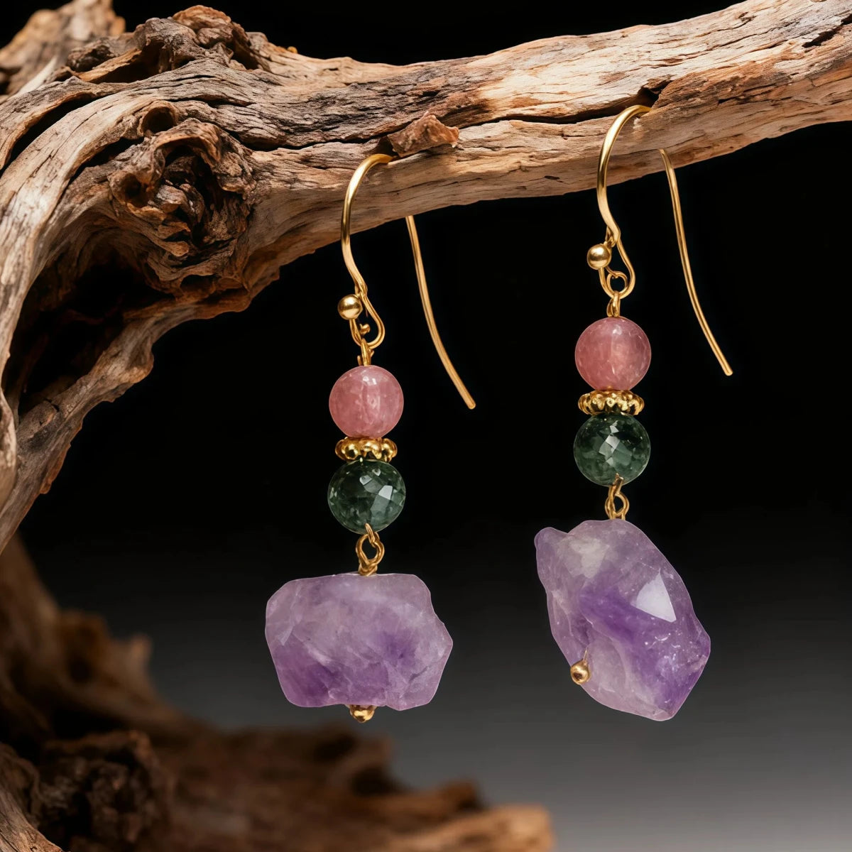Pair of earrings with purple and green gemstones on a dark background