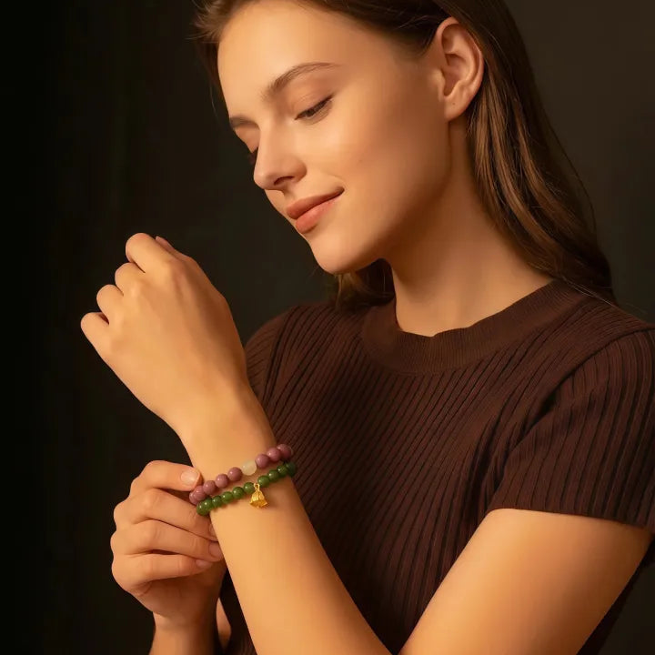 Woman wearing a brown top and bracelets on a dark background