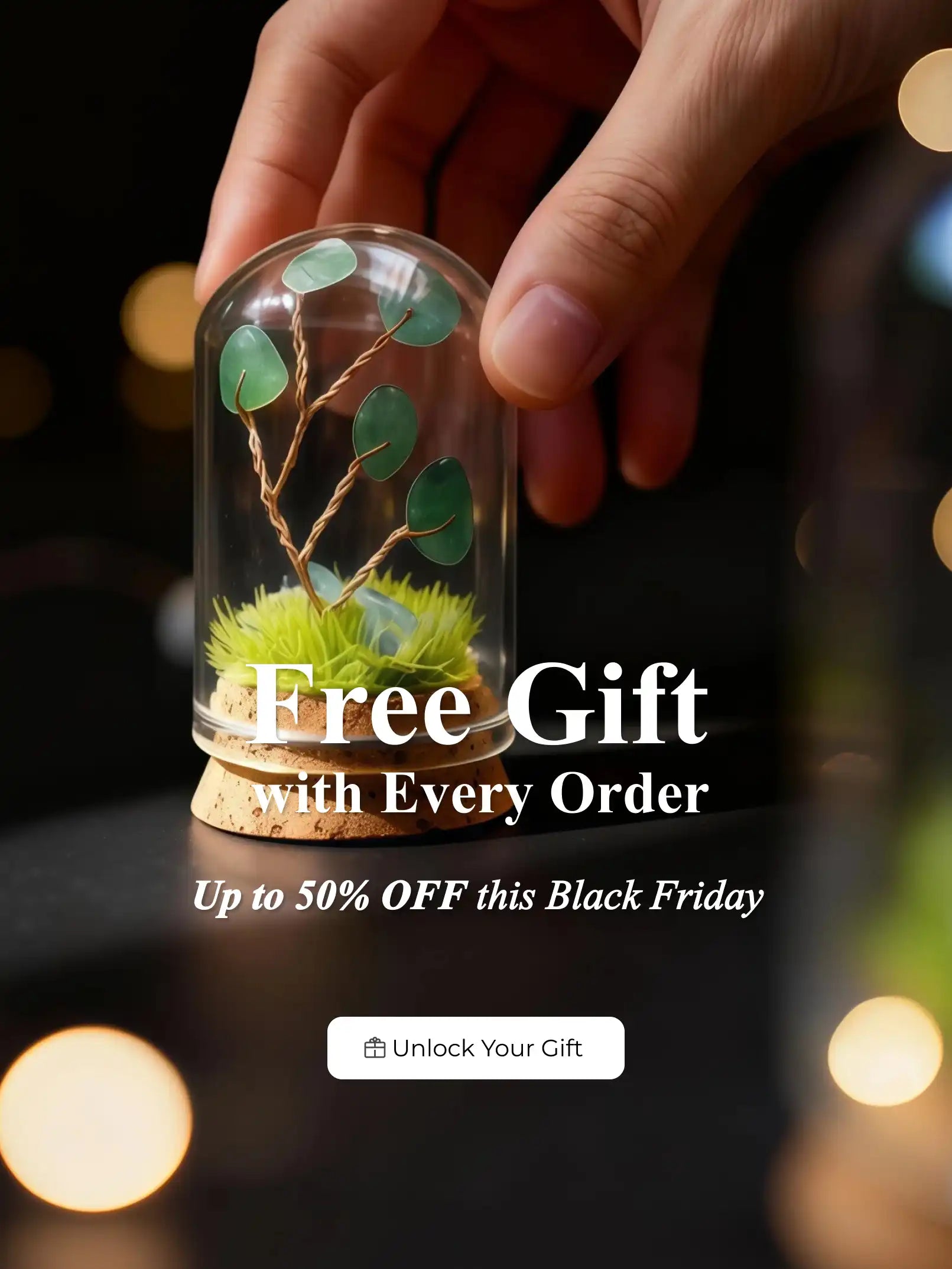 Hand holding a glass dome with a small crystal tree of life, promotional text overlay for free gift and Black Friday offer.