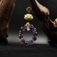Bodhi Root for Mindfulness & Protection, Amethyst beaded necklace with gold accents and a white flower pendant on a dark background