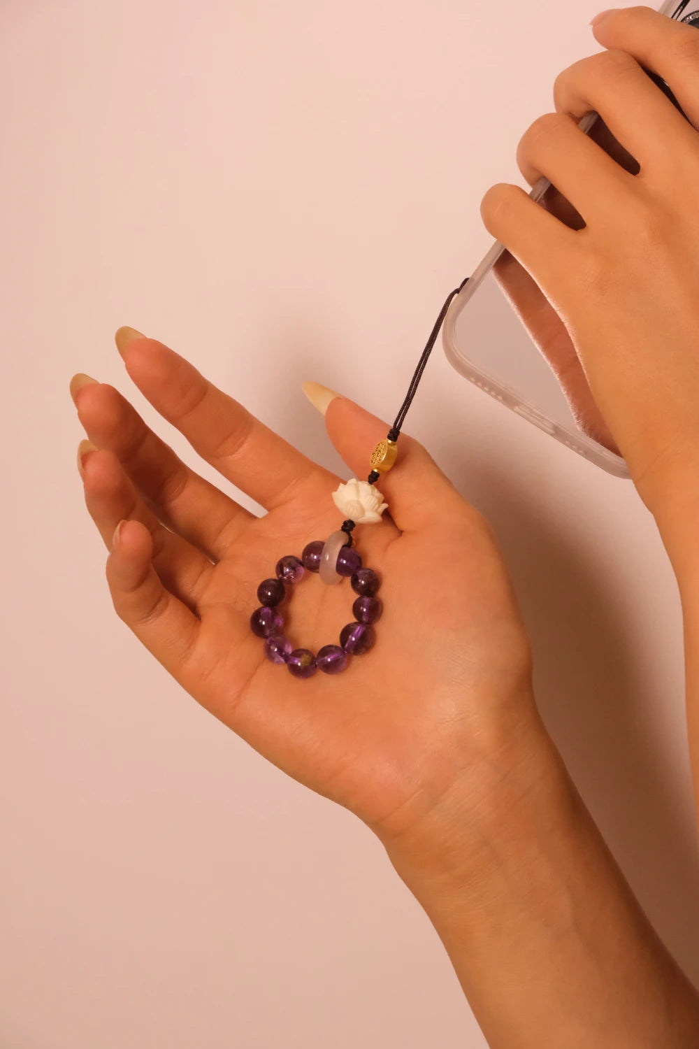 Hand holding a small purple beaded object against a plain background, Feng Shui Keychain & Phone Pendant