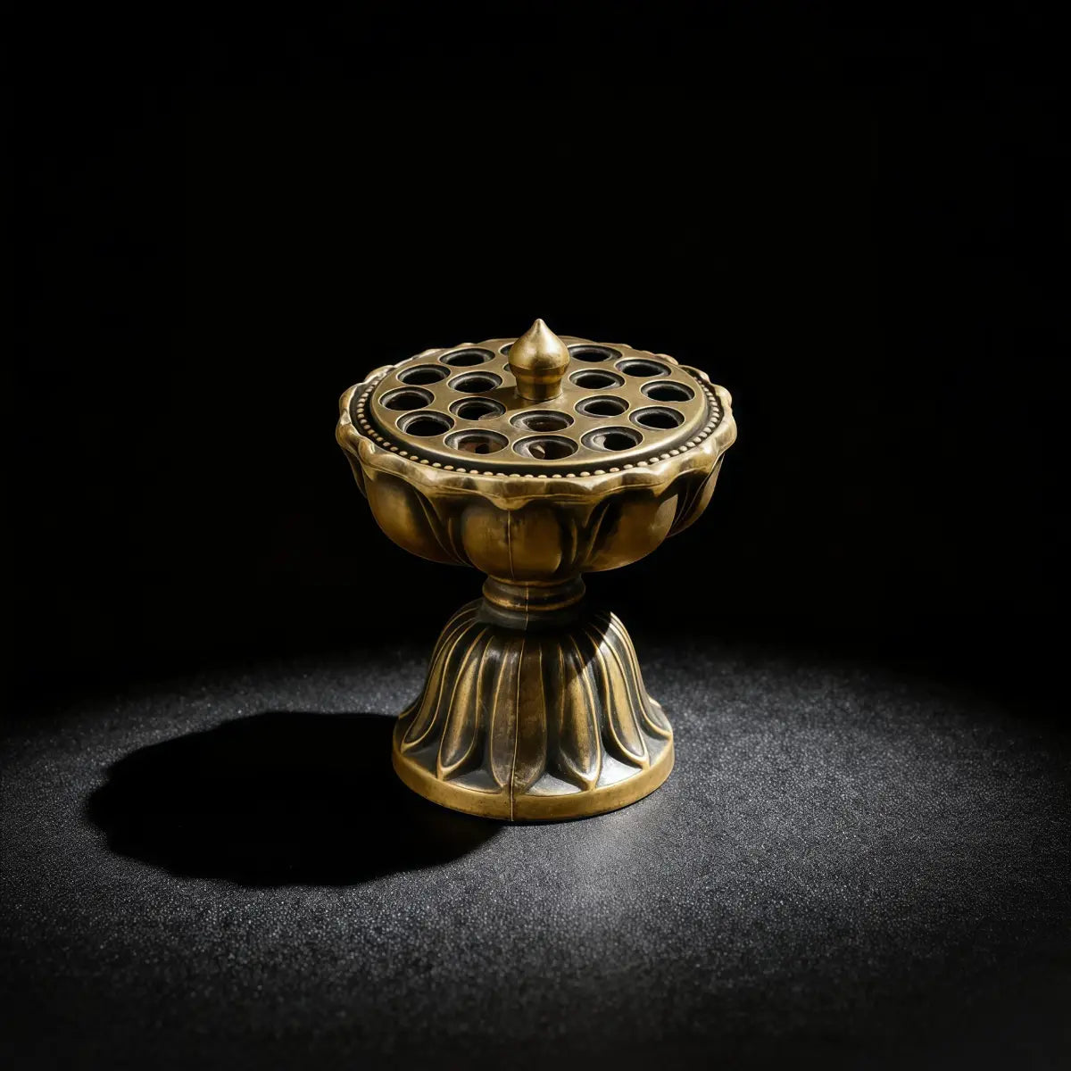 Bronze lotus-shaped incense burner on a black background