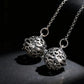 Silver necklace with intricate spherical pendants on a dark background