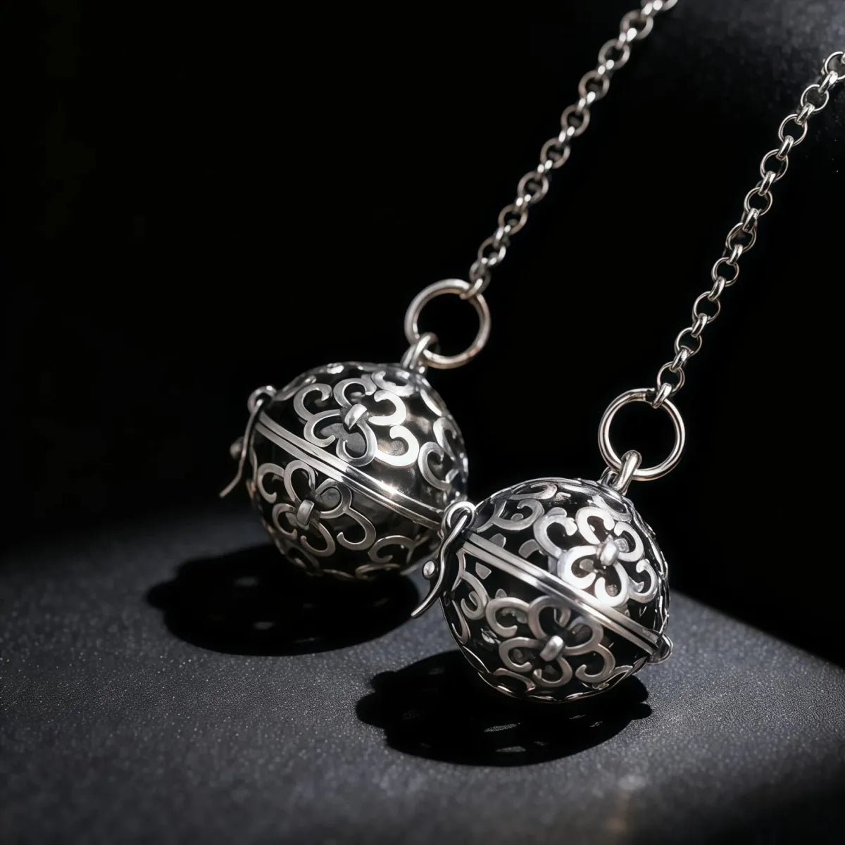 Silver necklace with intricate spherical pendants on a dark background
