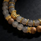Necklace with GrayAgate and gold accents on a dark background