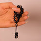 Hand holding Grounding & Protection – Tibetan Meditation Spinner against a beige background