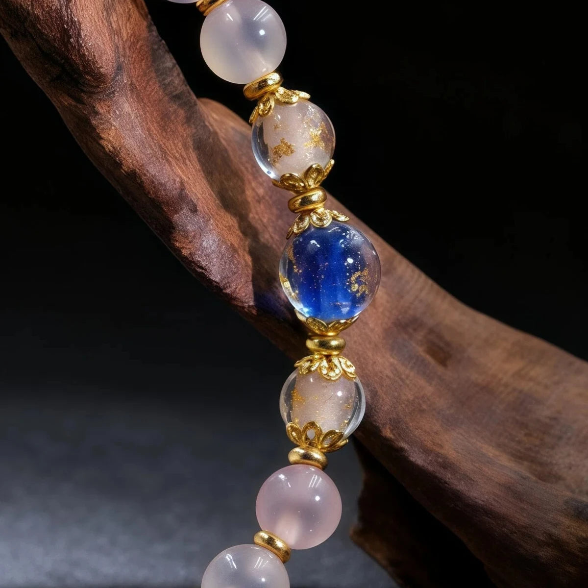 Detail of bracelet with blue and pink beads on a dark background