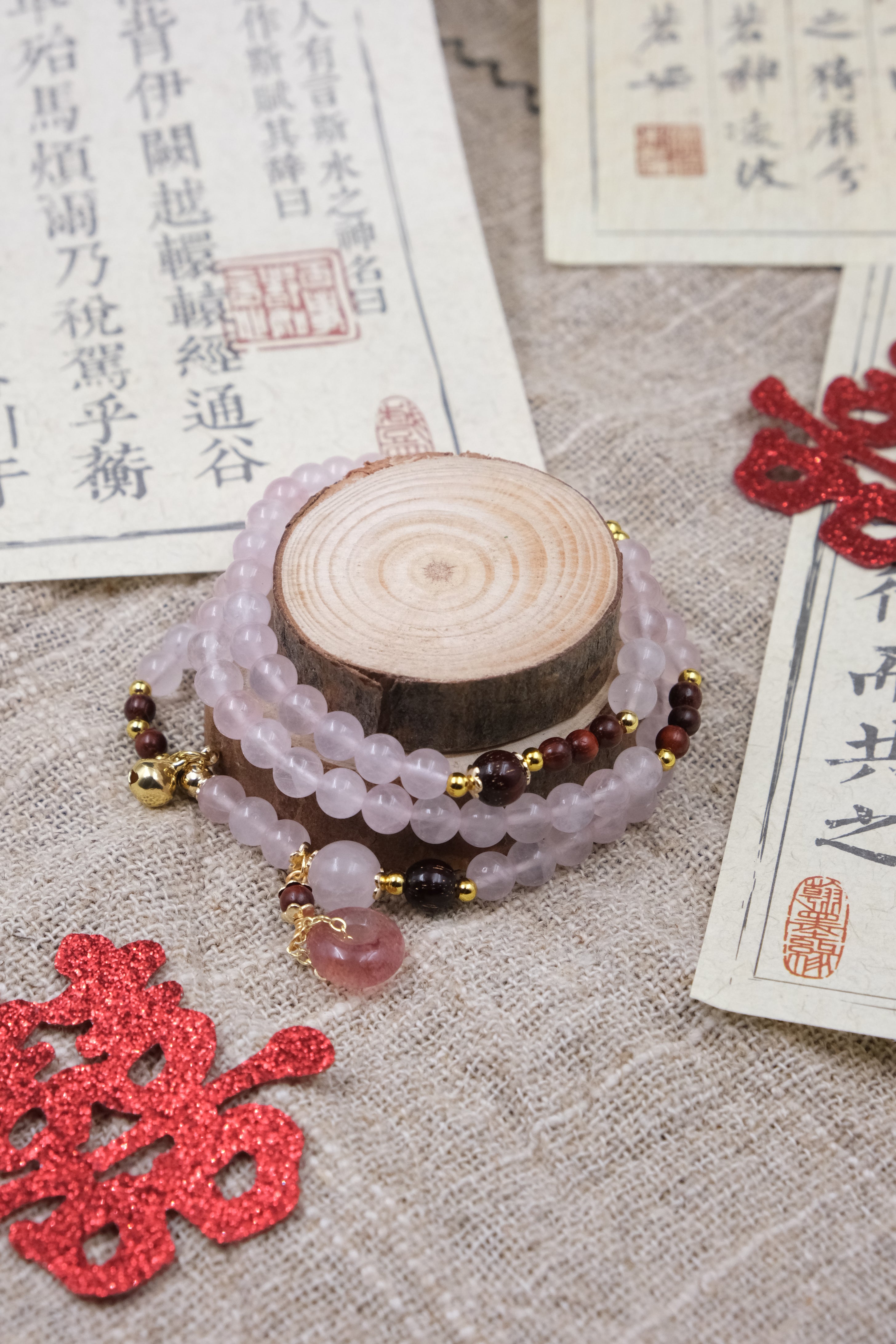 Decorative bracelet with beads on a wooden block, surrounded by red decorative elements and Chinese text.