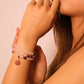 Close-up of a woman's arm wearing a Rose Quartz Amulet Bracelet against a neutral background