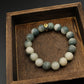 Tibetan Bracelet with Six-Word Mantra on a wooden tray with a dark background