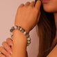 Woman wearing a Inner Balance & Protection – Tibetan Six-Word Mantra Bracelet on a pink background