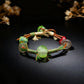 Bracelet with green beads and woven design on a dark background