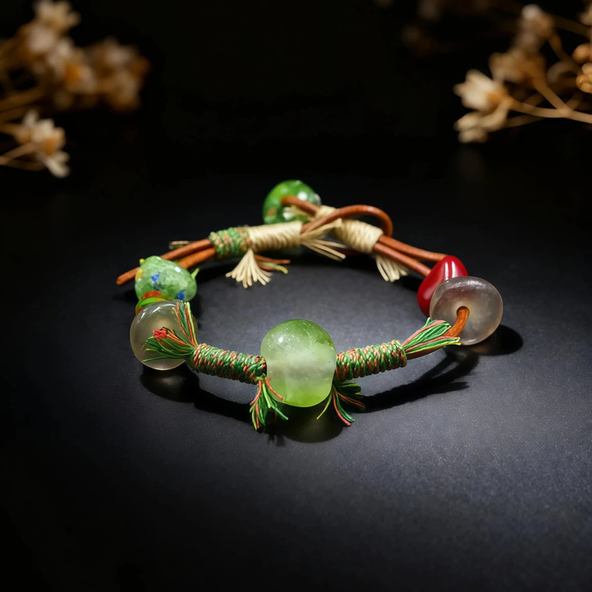 Bracelet with green beads and woven design on a dark background
