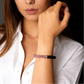 Woman wearing a bracelet with Black Obsidian and Rose Quartz beads, with a dark background