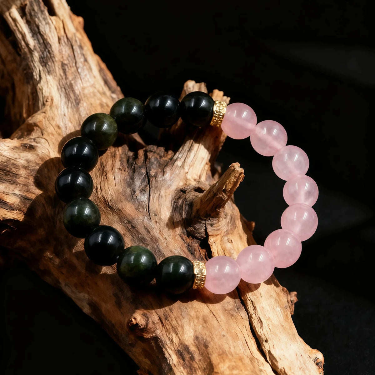 Two beaded bracelets, one black and one pink, on a wooden surface.