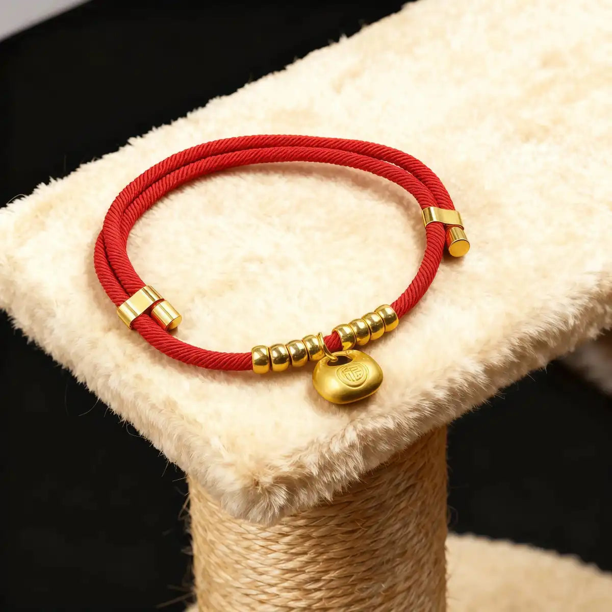 Red collar with gold lucky pouch charm displayed on cat tree, showing craftsmanship, pendant detail, and overall design.
