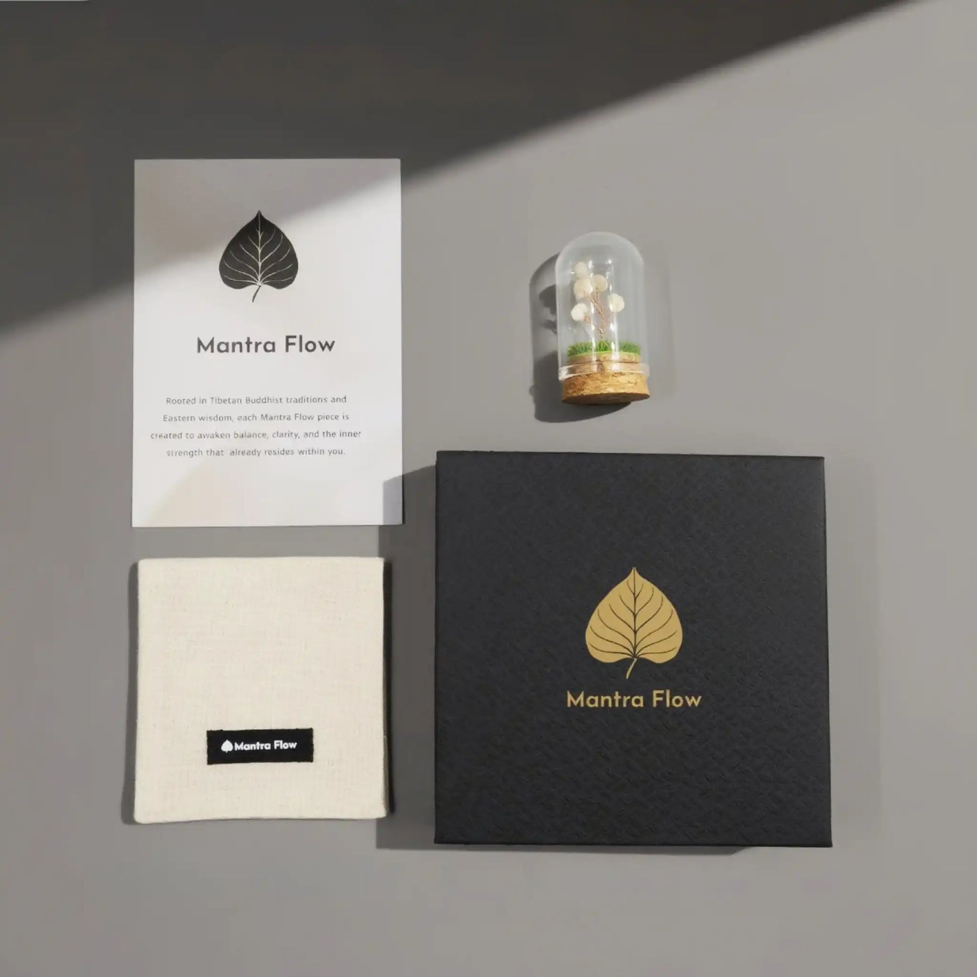 Mantra Flow products including a card, small box, and crystal tree of life as free gift on a gray surface.