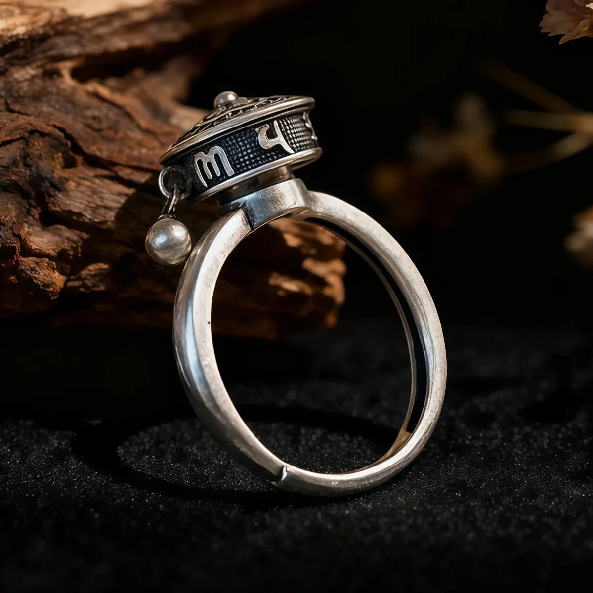 Silver ring with decorative top on a dark background