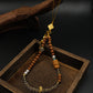 Calm & Positivity – Sandalwood Buddha Charm with gold accents on a wooden tray against a dark background