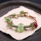 Intention & Harmony – Forest Ritual Liuli Bracelet with green and red beads on a dark surface