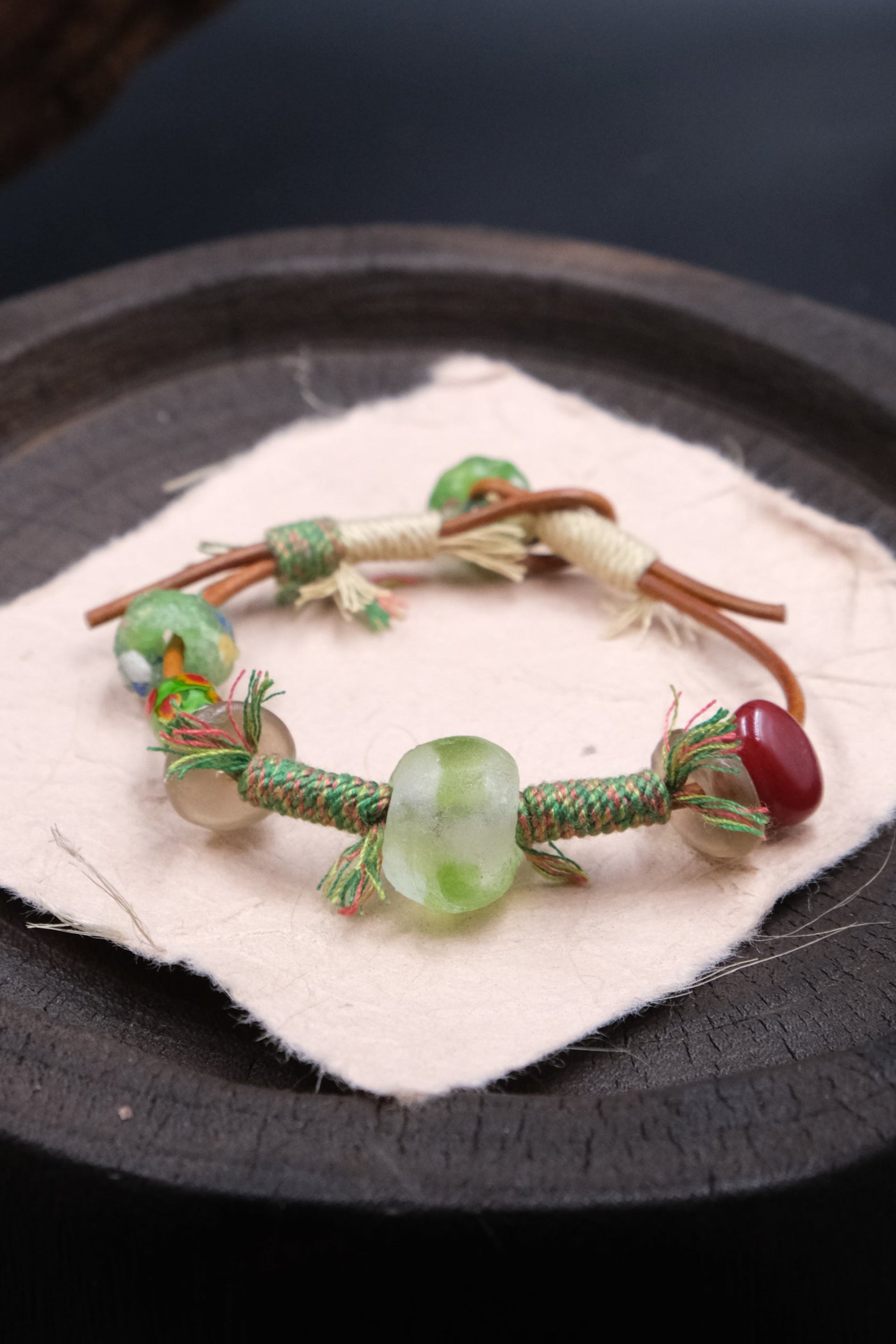 Intention & Harmony – Forest Ritual Liuli Bracelet with green and red beads on a dark surface