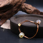 Unique Sun Spirit Bracelet adorned with ancient Liuli beads, strung on brown leather cord, resting on a dark - toned wooden disc, with textured, weathered wood in the background, promoting grounding and inner clarity. 