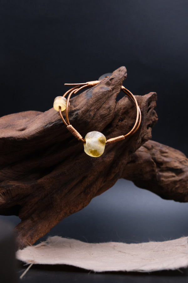 Unique Sun Spirit bracelet with ancient liuli beads for grounding and inner clarity, displayed on driftwood.