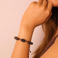 Close-up of Tibetan-style bracelet made of stones, wood, and liuli beads, designed for spiritual harmony.
