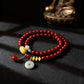 Red beaded bracelet with colorful beads on a dark surface