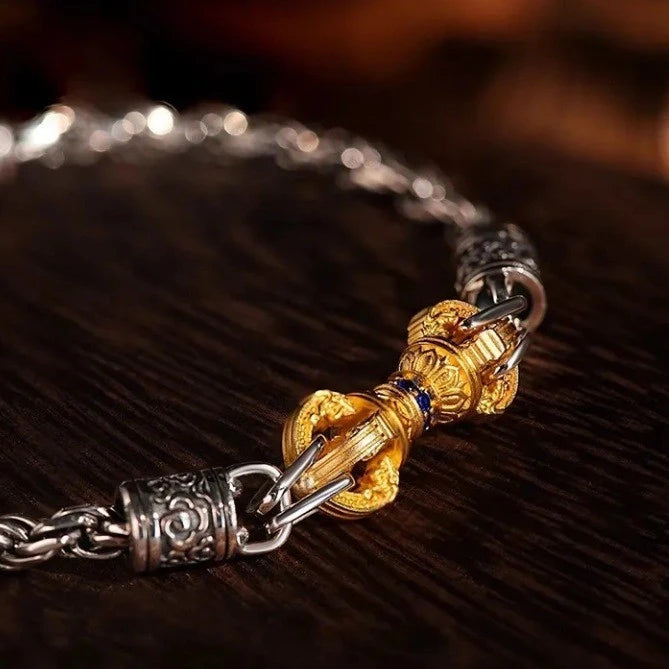 Close-up of a silver and gold bracelet on a dark wooden surface