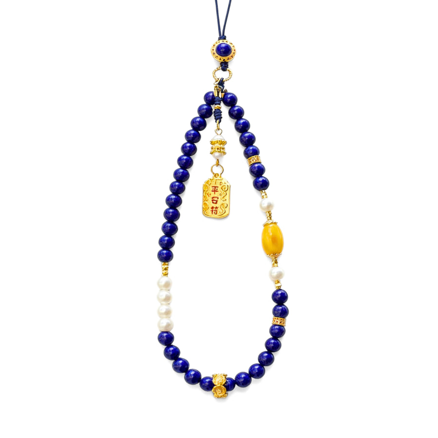 Necklace with blue Lapis Lazuli beads, yellow accents, and a gold pendant on a white background