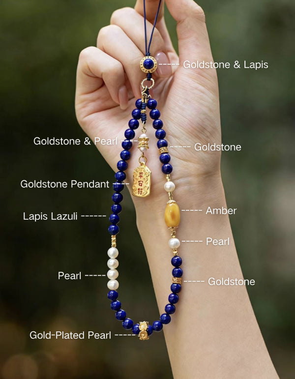 Hand holding a beaded necklace with labeled stones against a blurred natural background
