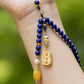 Beaded necklace with blue, gold, and yellow beads on a blurred green background