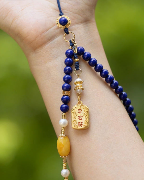 Beaded necklace with blue, gold, and yellow beads on a blurred green background