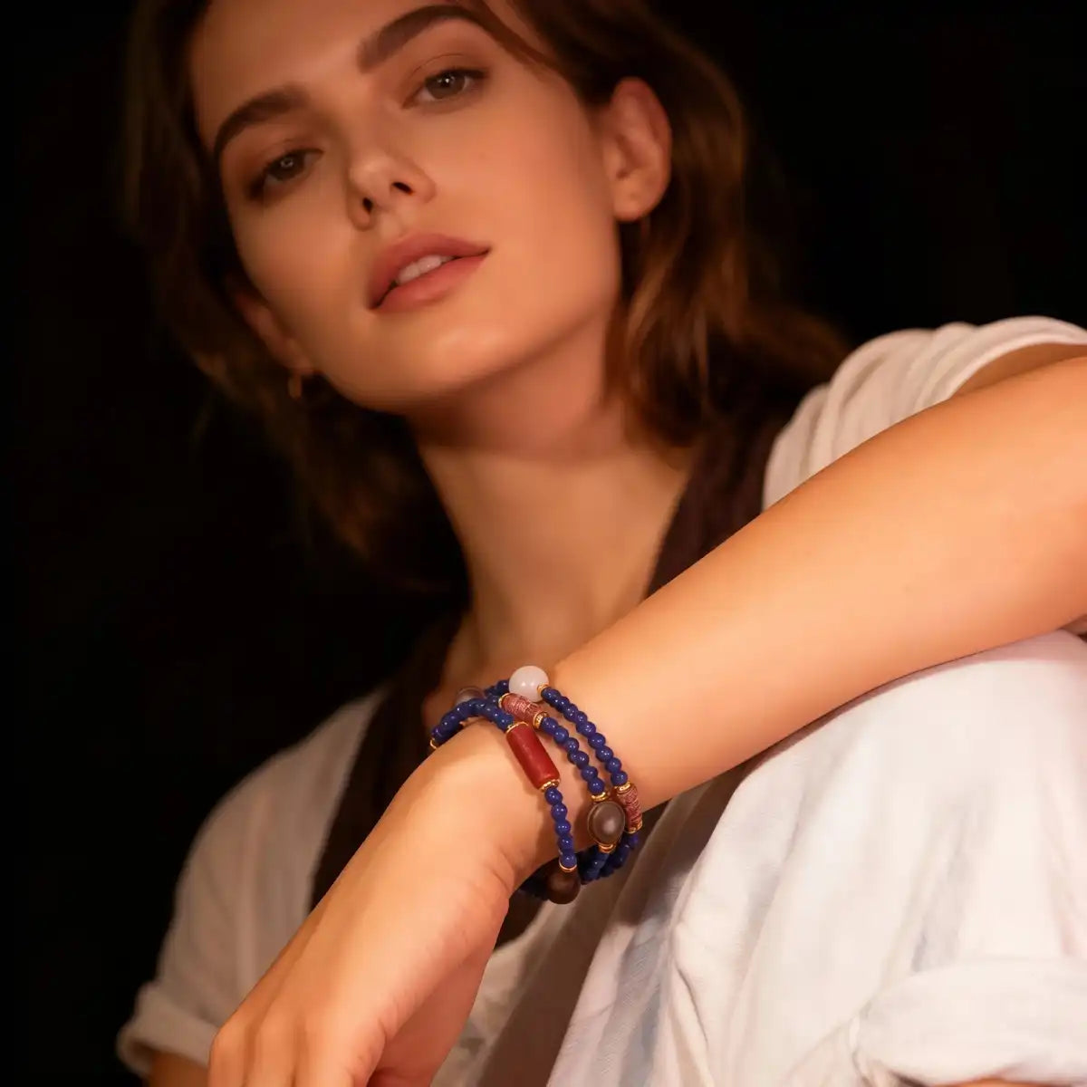 Woman wearing a Triple Lapis Lazuli Mala Bracelet with beads on a dark background