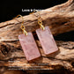 Rose Quartz earrings with gold-plated metal alloy on a wooden background, labeled 'Love & Connection'.